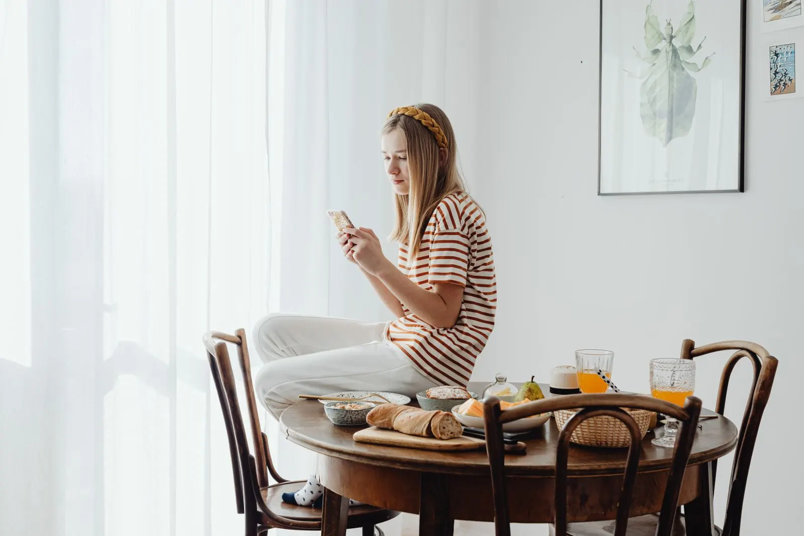 Une personne utilise son téléphone à une table de petit-déjeuner dressée